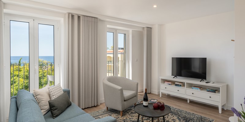 Cozy Living Room Featuring A Comfortable Couch A TV And A Stylish Table For Relaxation And Entertainment Ourmadeira