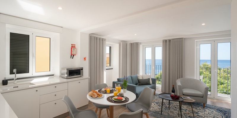 Open Concept Kitchen And Living Room With Panoramic Windows Revealing A Breathtaking View Of The Ocean By The Fort Of Old Town Apartments