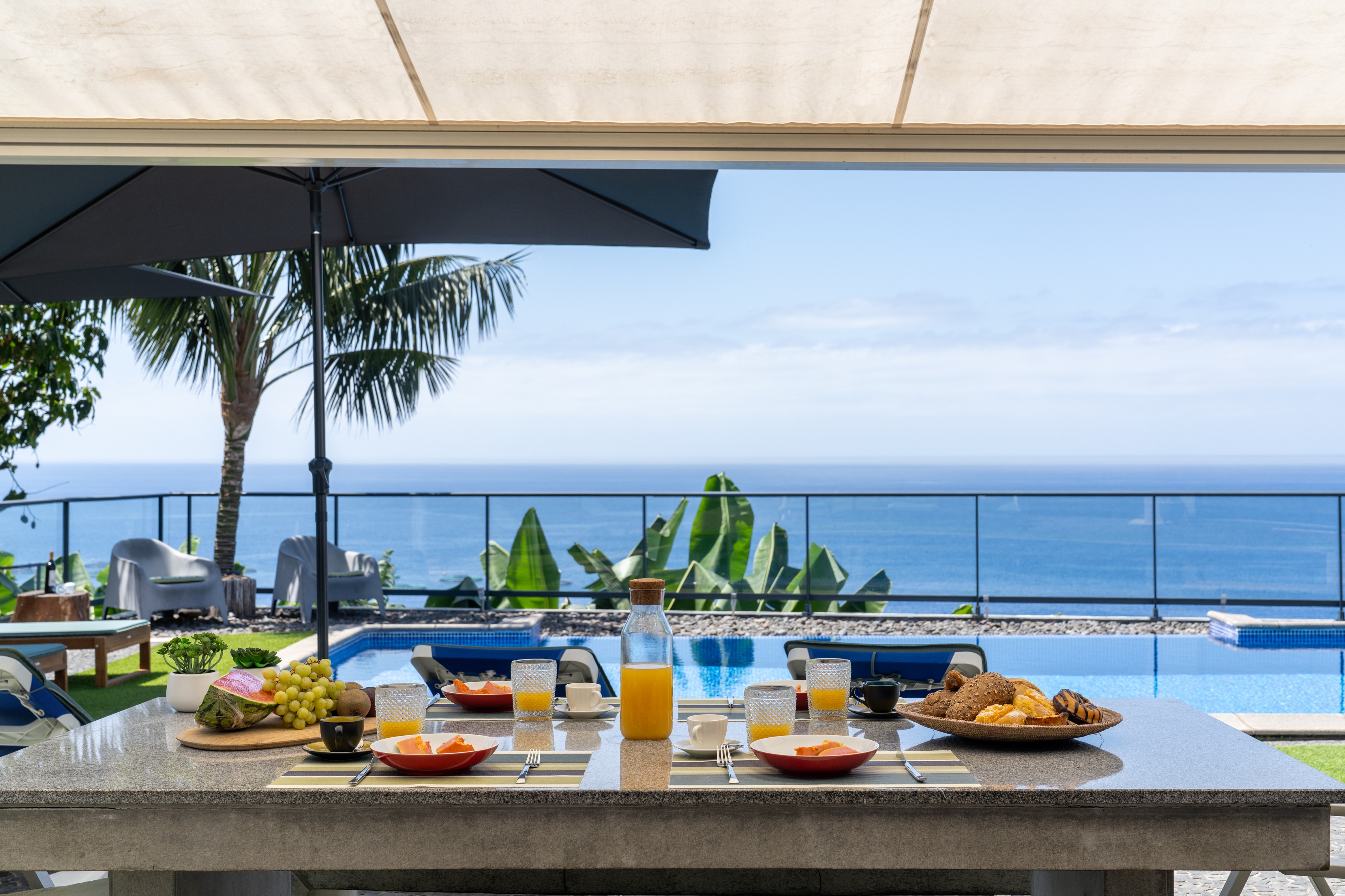 Outdoor Breakfast Setup By The Pool At Graycis House By Ourmadeira With Ocean Views On The Horizon And A Serene Coastal Atmosphere