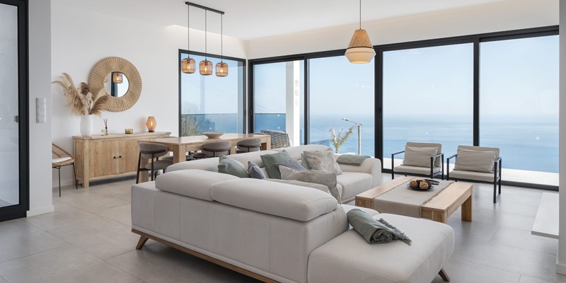 Living Area At Infinite Atlantic By Ourmadeira Featuring An L‑Shaped Sofa And Dining Table With Expansive Ocean Views As The Backdrop In Madeira
