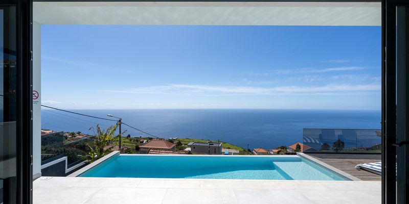 Living Room At Infinite Atlantic By Ourmadeira With A Large Open Window Framing The Infinity Pool And Uninterrupted Atlantic Ocean Views In Madeira