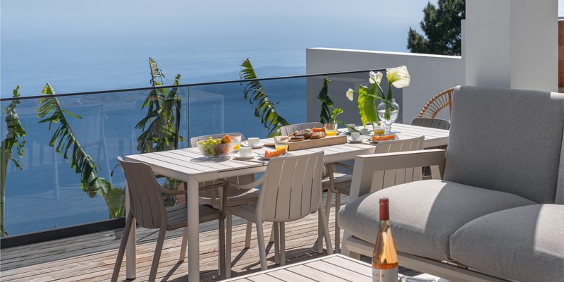 Outdoor Dining Area At Infinite Atlantic By Ourmadeira Featuring A Breakfast Setup With Panoramic Atlantic Ocean Views In Madeira