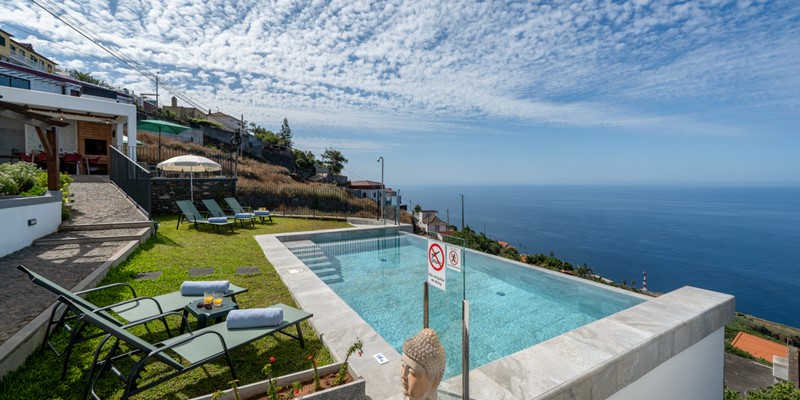 The Inviting Shared Swimming Pool Surrounded By Sun Loungers And Overlooking The Endless Blue Of The Atlantic Ocean At Ocean Hills By Ourmadeira